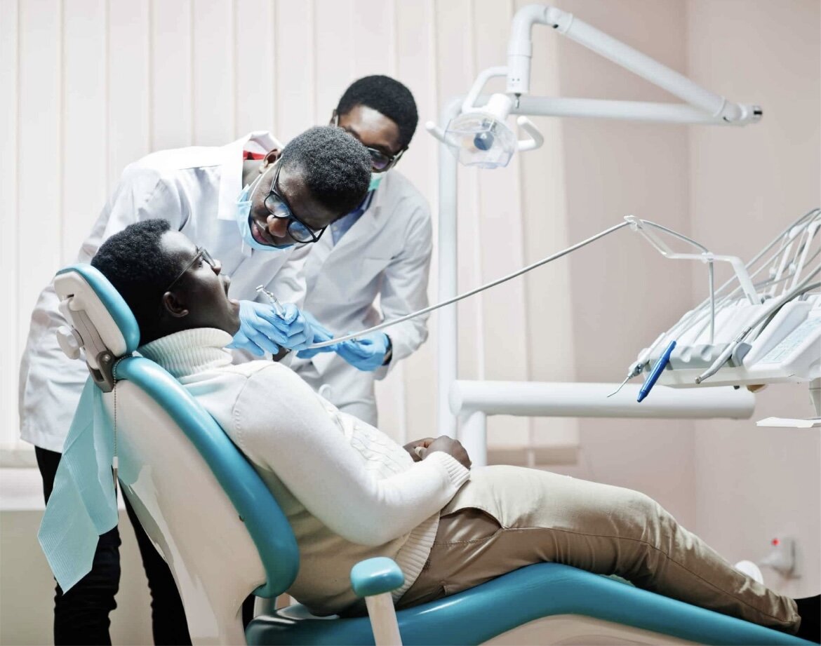 Dentist and assistant treating a patient in the dental chair